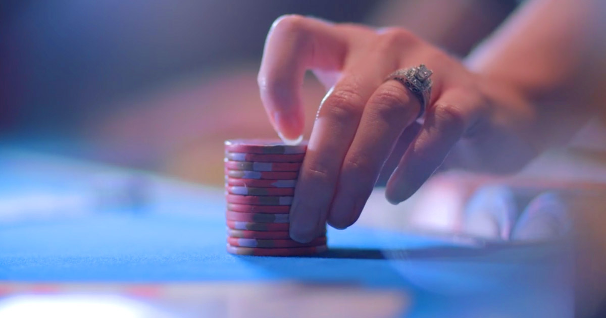 hand moving a stack of poker chips