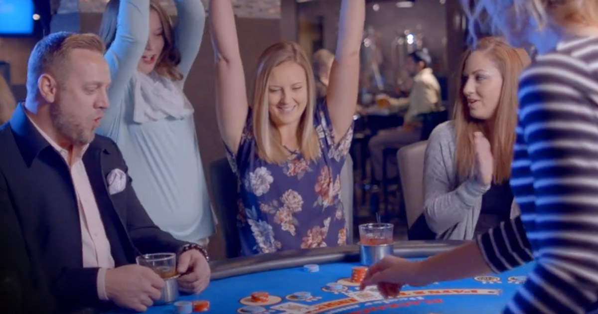 group of people celebrating a win at a poker table